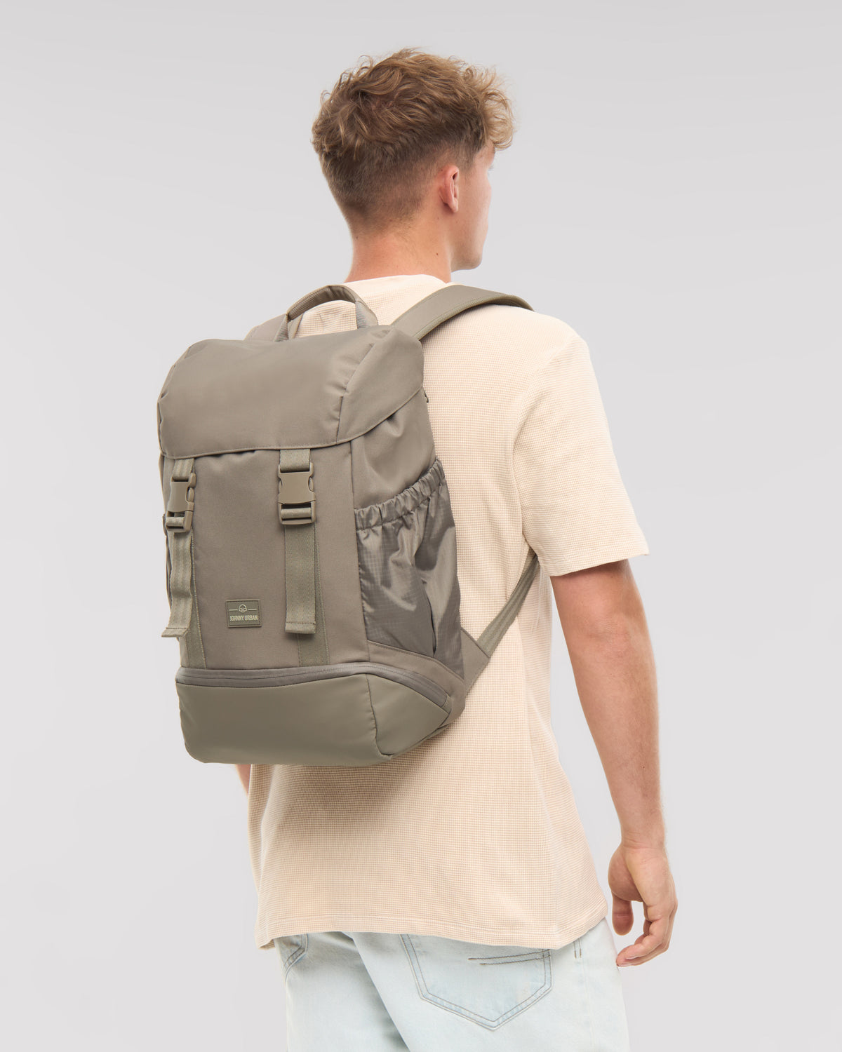 Mann trägt Rucksack 'Nico' in desert-grey, rechteckig mit Frontklappe und Seitentaschen