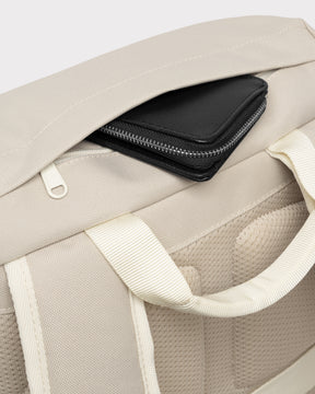 Beiger Johnny Urban Rucksack 'Nico' mit verstecktem Reißverschlussfach, aus dem eine schwarze Geldbörse herausragt