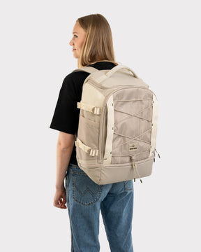 Frau trägt beigen Johnny Urban Rucksack 'Jack' mit verstellbaren Gurten und elastischem Netzt auf der Vorderseite
