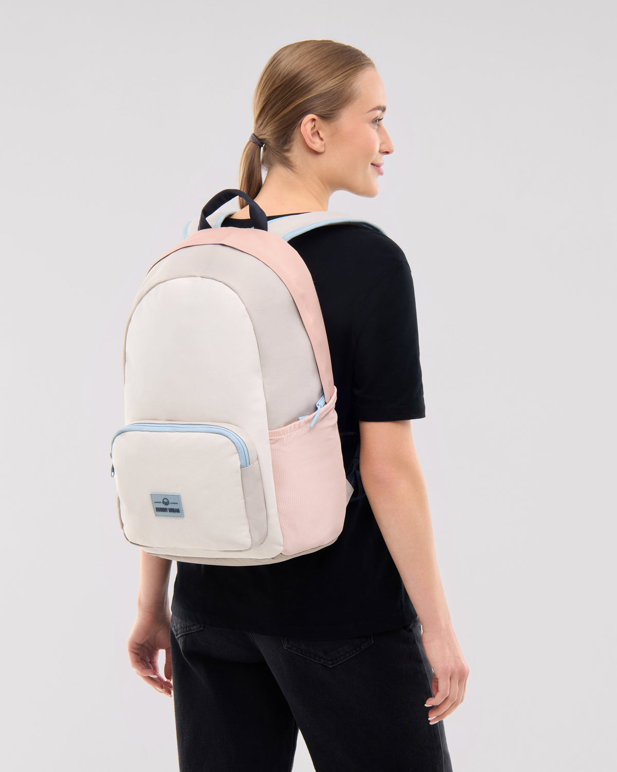 Frau trägt den Johnny Urban Rucksack 'Mo' in Sand-Rose, seitliche Ansicht