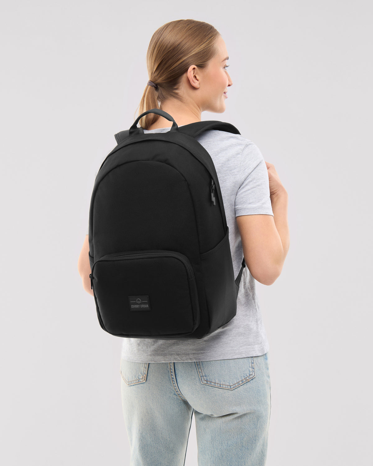 Frau trägt schwarzen Rucksack 'Mo' von Johnny Urban, einfache Form, glatte Oberfläche