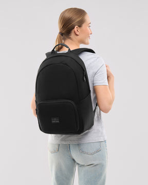 Frau trägt schwarzen Rucksack 'Mo' von Johnny Urban, einfache Form, glatte Oberfläche