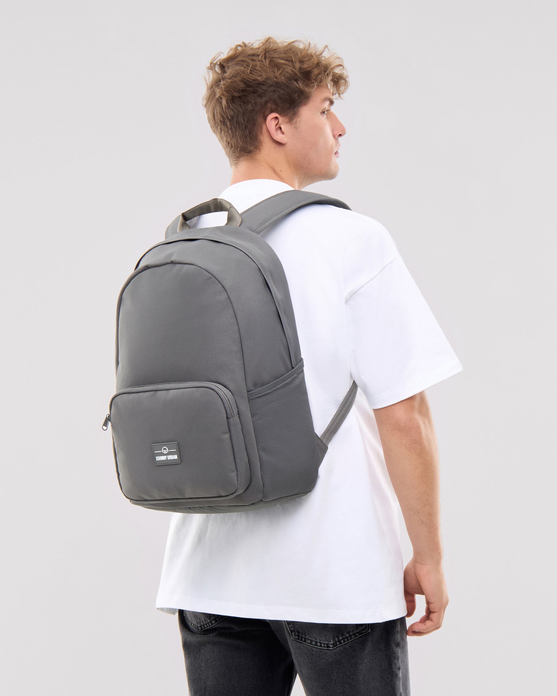 Mann trägt dunkelgrauen Rucksack 'Mo' von Johnny Urban, weißes T-Shirt, Rückenansicht