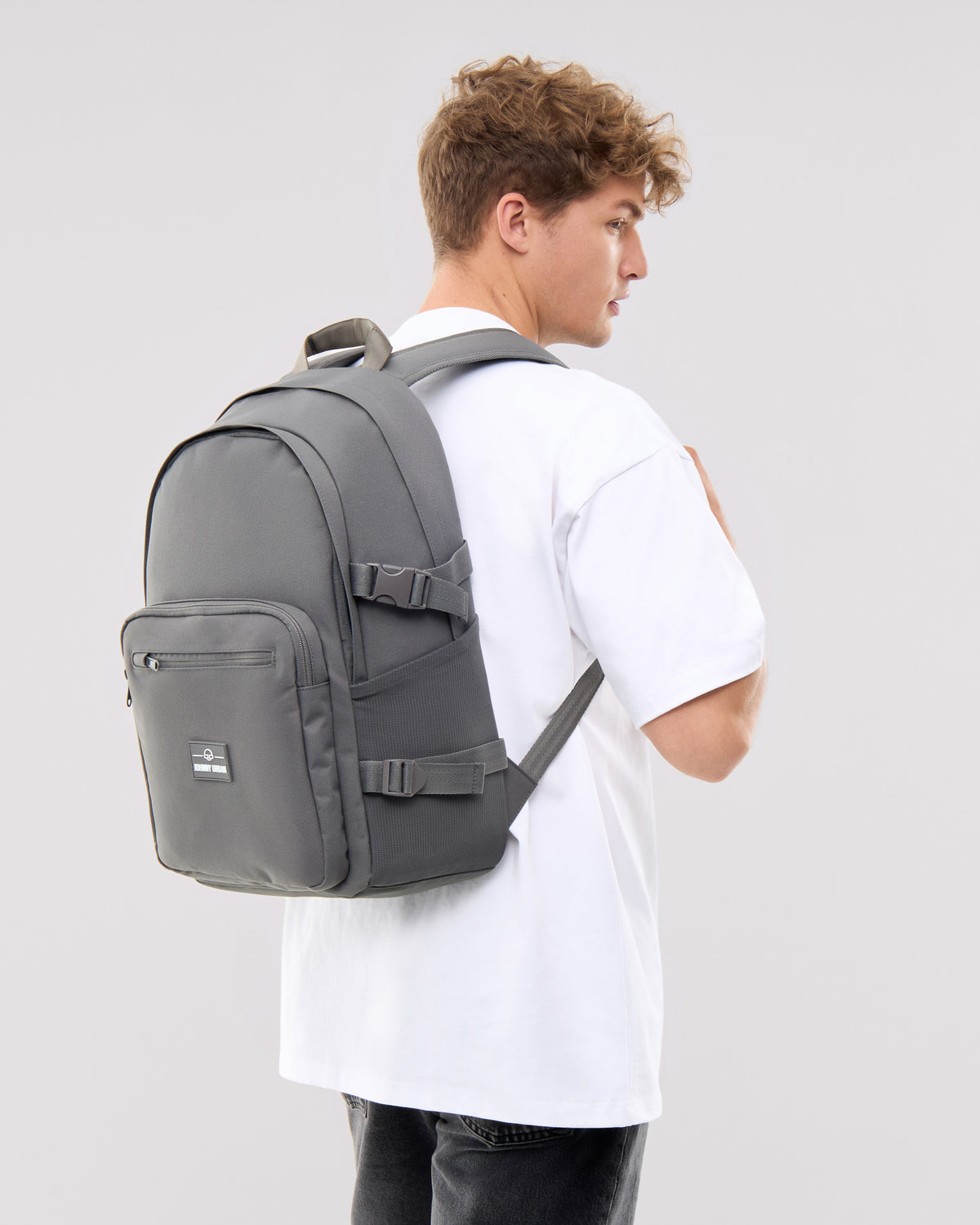 Mann trägt dunkelgrauen Rucksack 'Lian' mit mehreren Fächern und verstellbaren Gurten