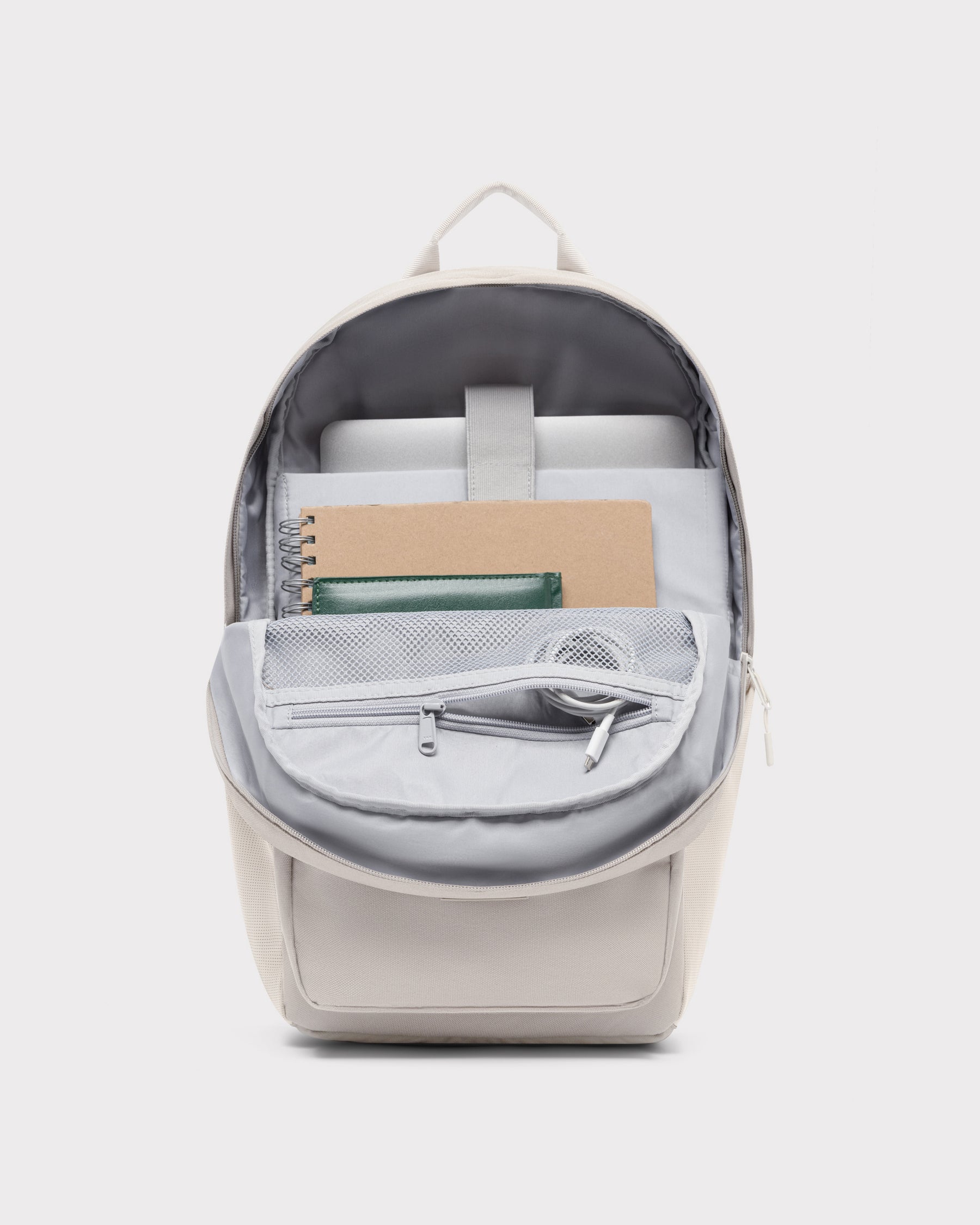 Sandfarbener Rucksack 'Mo' von Johnny Urban mit geöffnetem Hauptfach, zeigt Laptopfach, Notizbuch, Brieftasche und Kopfhörer