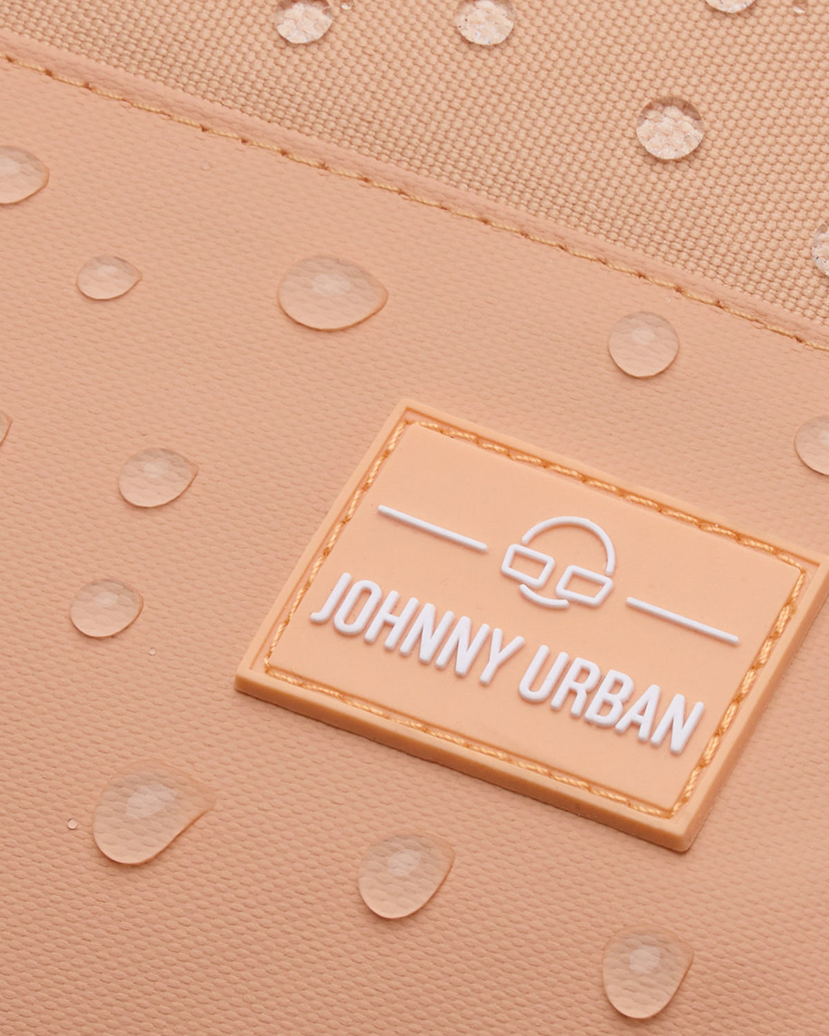 Nahaufnahme des wasserabweisenden Stoffes des Johnny Urban Rucksacks 'Mika' in Pfirsich mit Wassertröpfchen