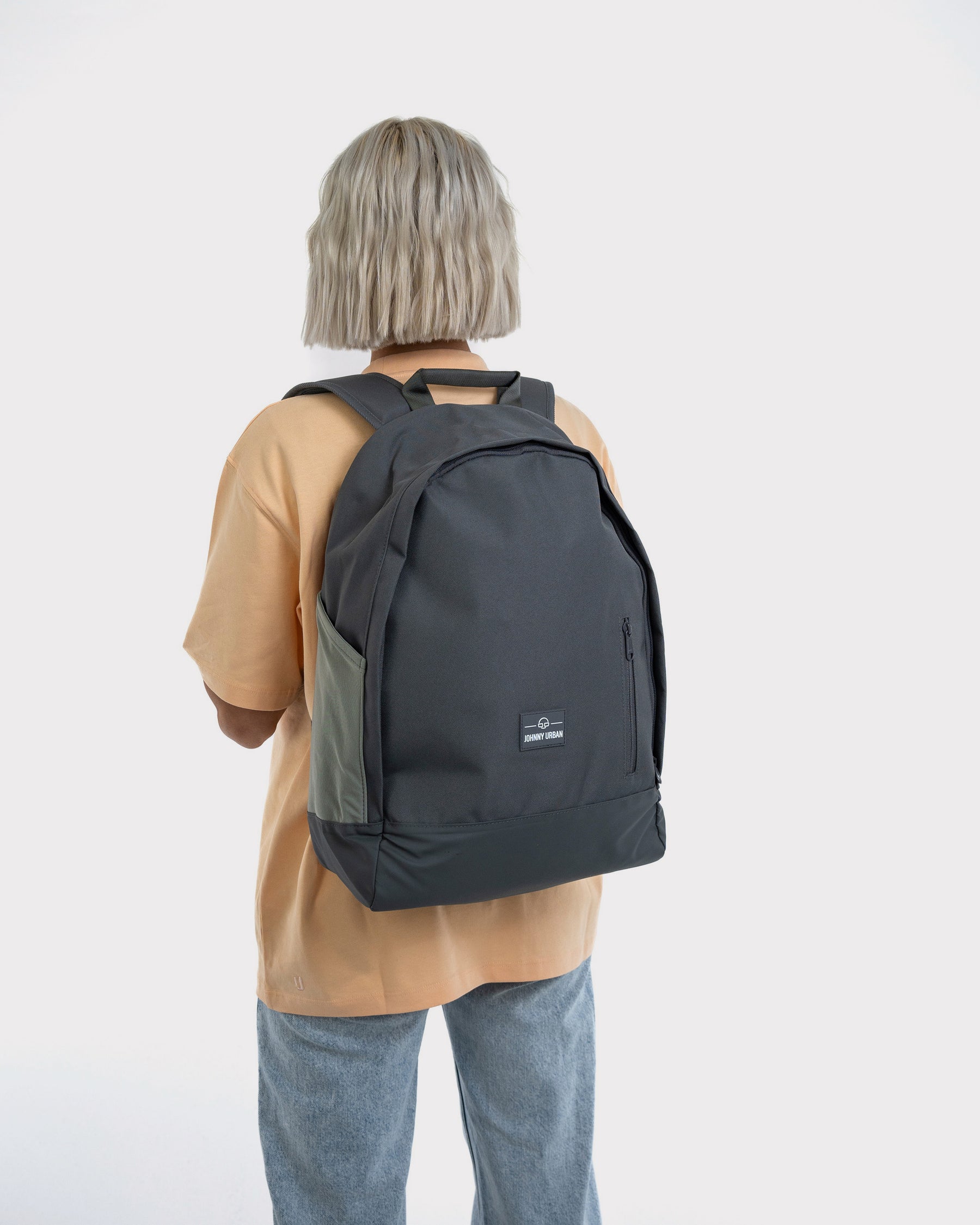 Frau mit mittellangem blondem Haar trägt grauen Rucksack 'Neo' von Johnny Urban mit Seitentaschen