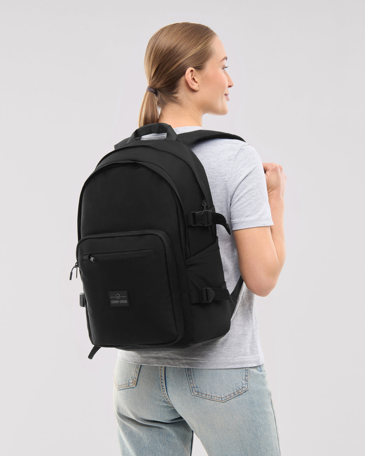 Schwarzer Rucksack 'Lian' von Johnny Urban an einer Frau, die ein graues T-Shirt und blaue Jeans trägt