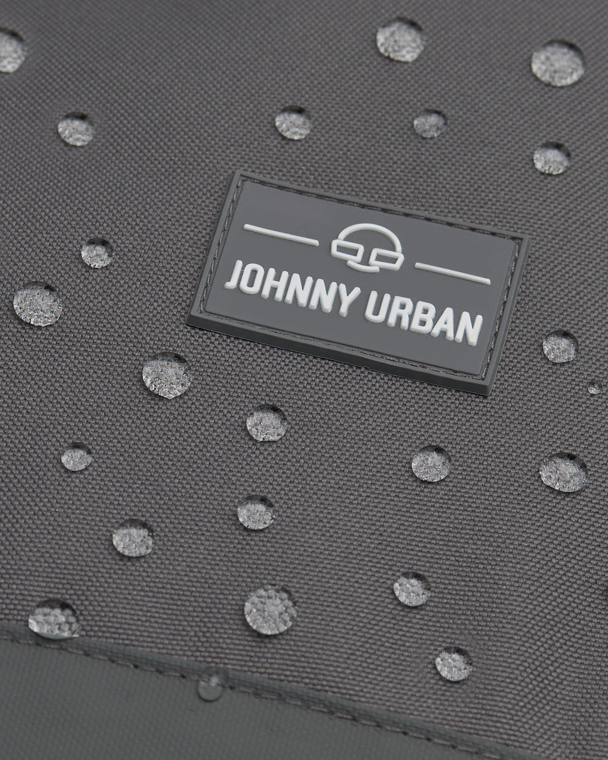 Wasserabweisendes graues Material mit Johnny Urban Logo und Wasserperlen