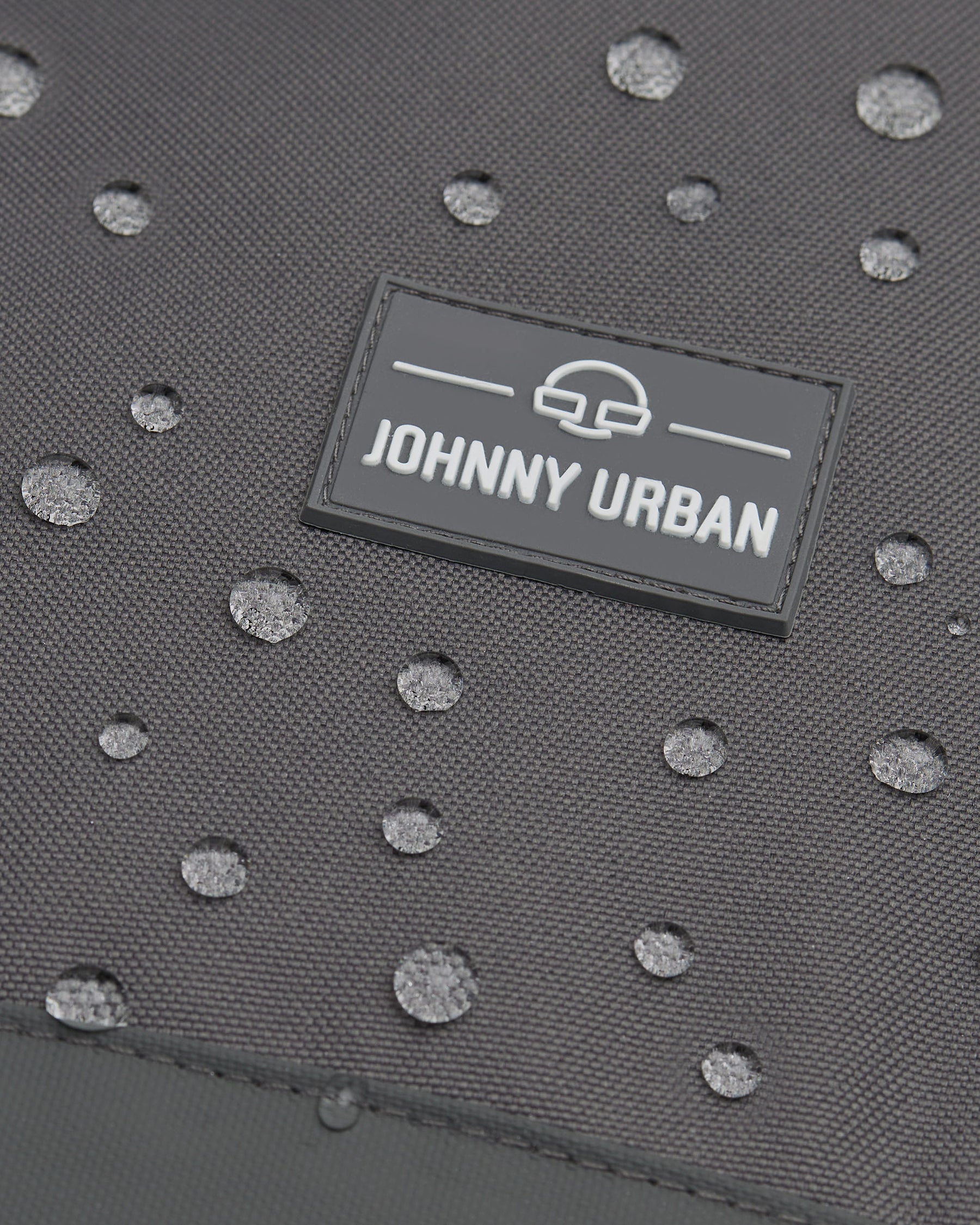 Wasserabweisendes graues Material mit Johnny Urban Logo und Wasserperlen