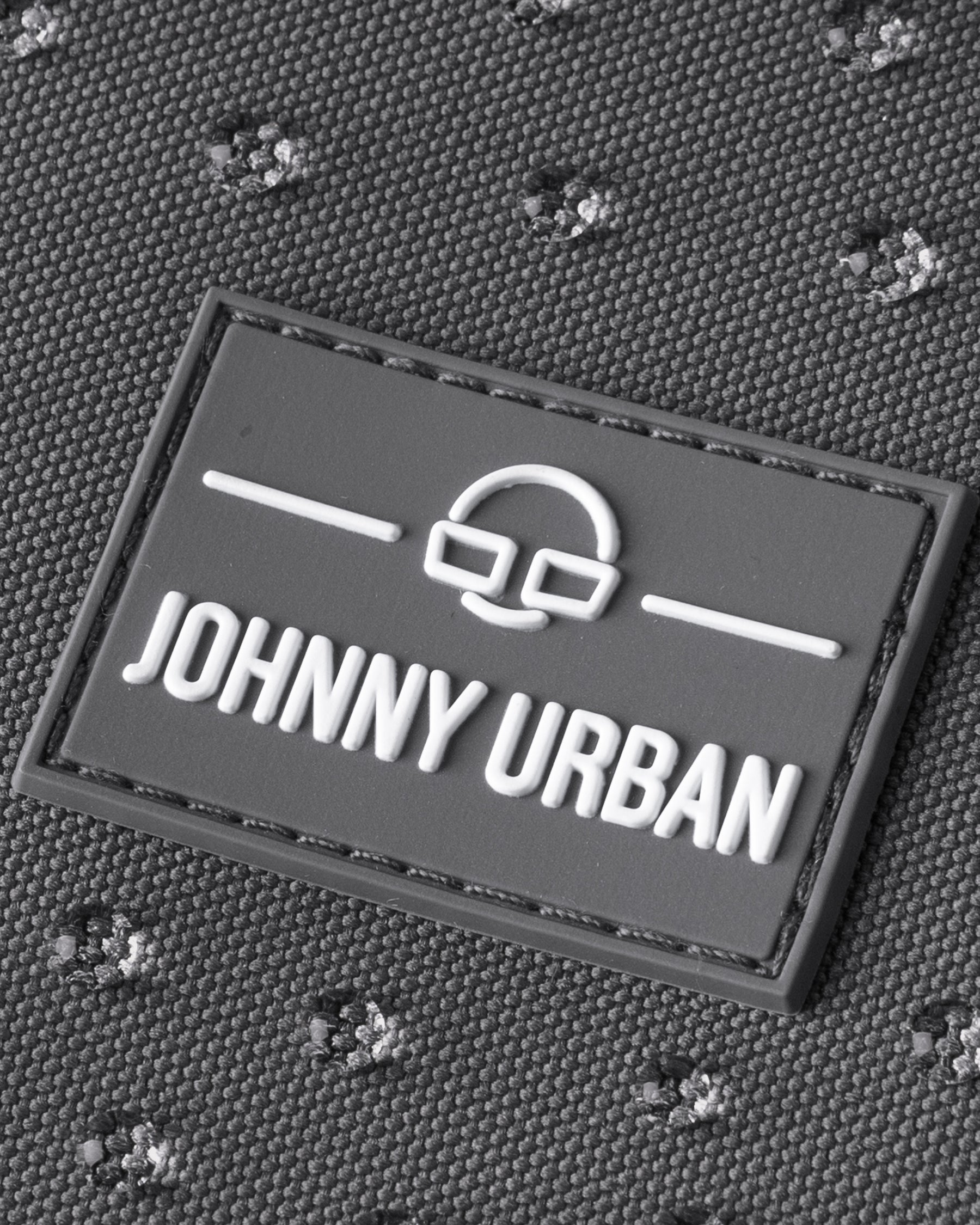Johnny Urban Logo auf dunkelgrauem, wasserfestem Rucksackstoff mit Struktur