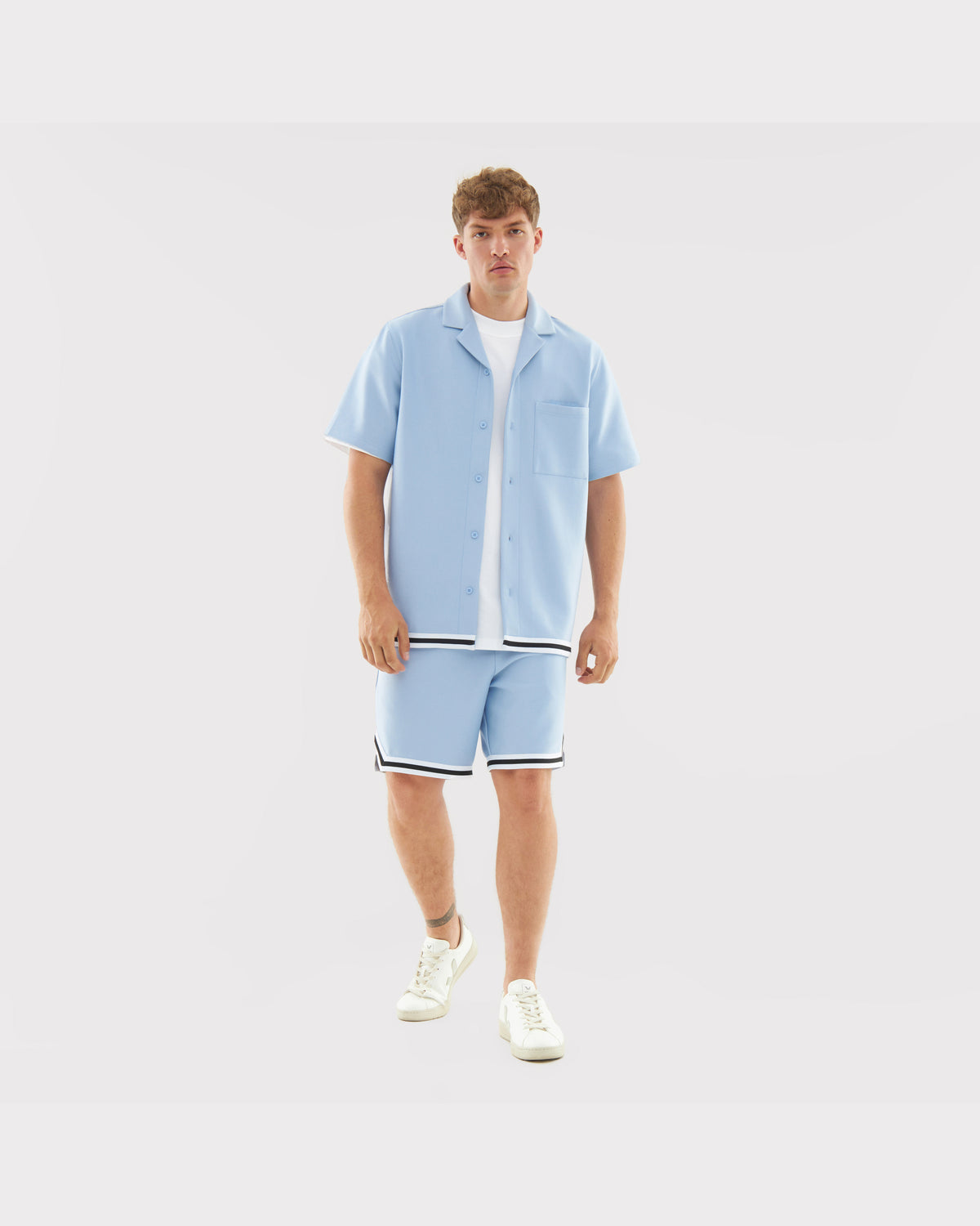 Mann in hellblauem Sommerhemd und Shorts mit schwarzen und weißen Streifen, Teil des Sets 'Parker'