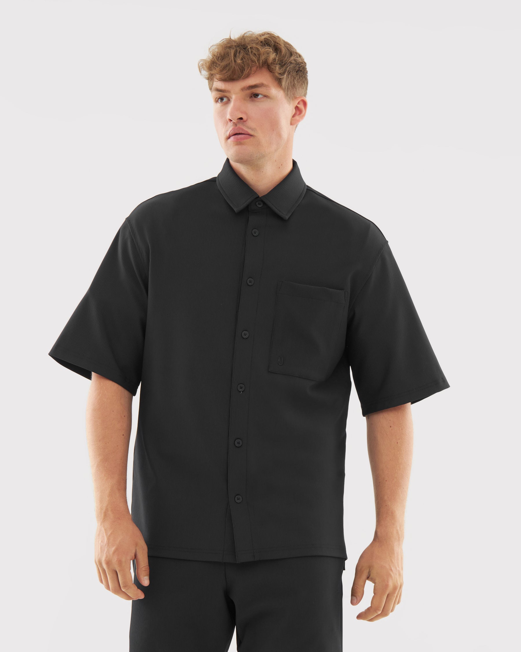 Mann trägt schwarze kurzärmlige Hemdjacke mit Brusttasche aus Set 'Mason'