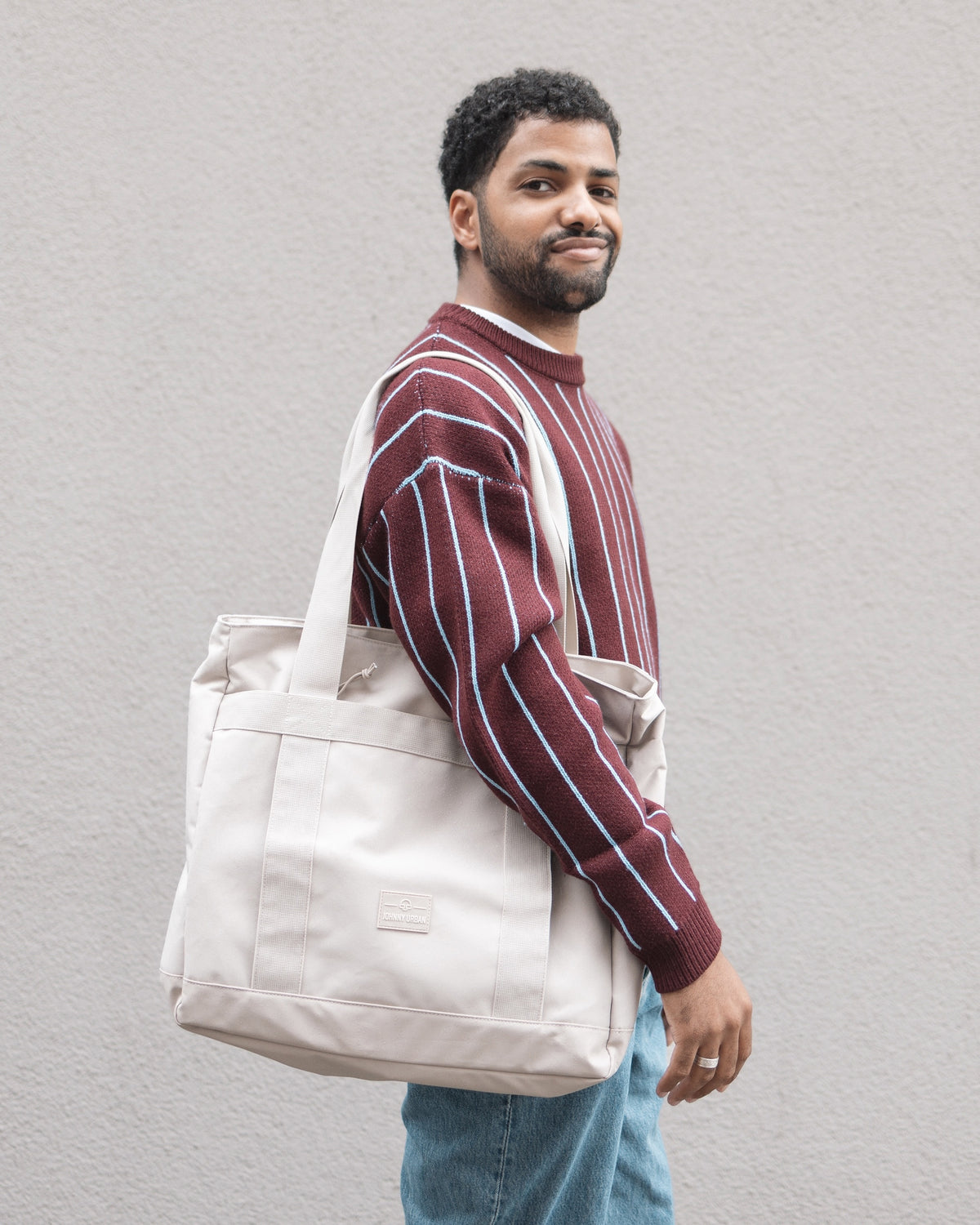 Unser männliches Model präsentiert sich hier mit der Johnny Urban Shopperbag "Kim" in beige.