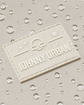 Nahaufnahme des wasserabweisenden Johnny Urban Logos auf sandfarbenem Shopper-Material mit Wassertropfen
