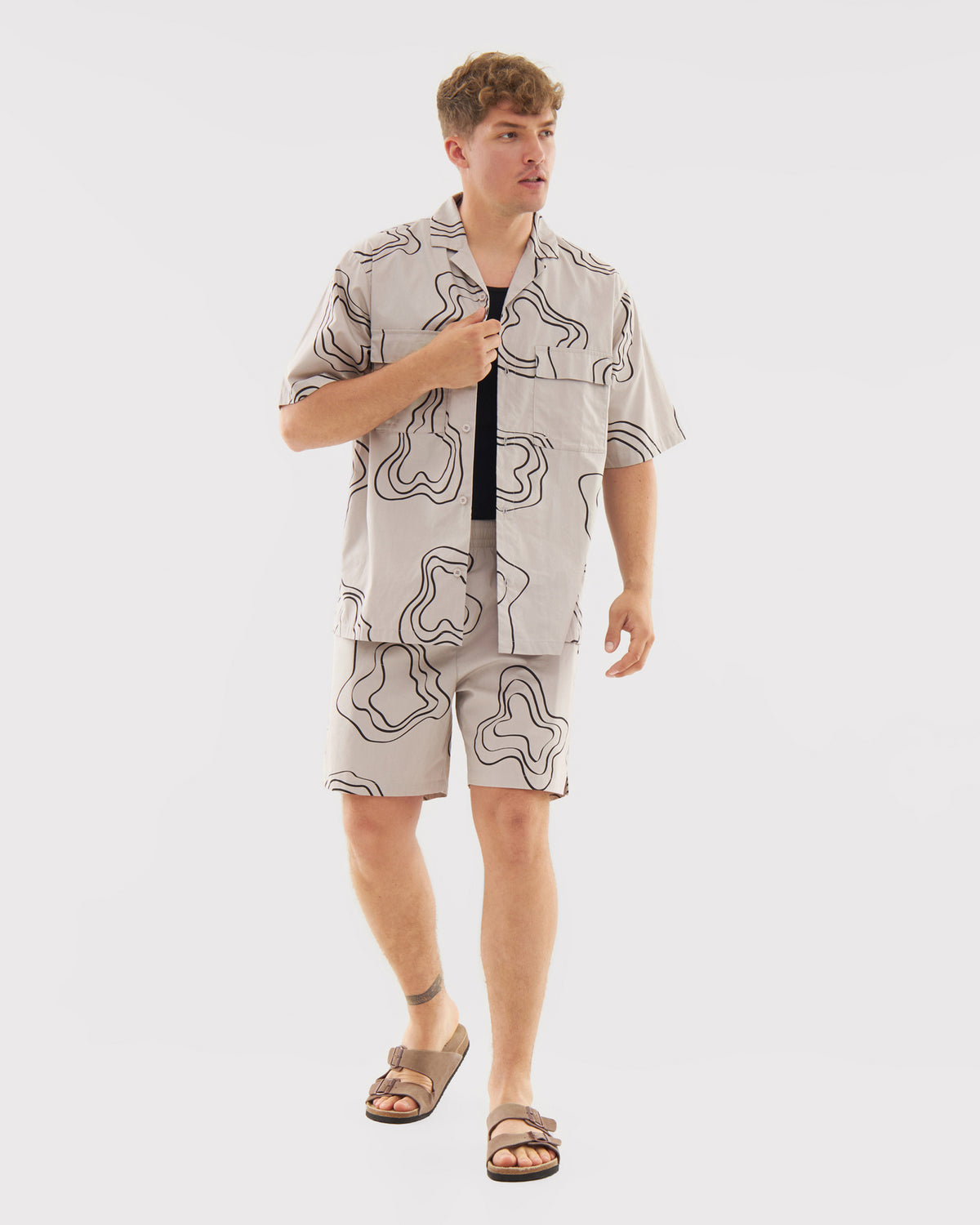 Mann trägt gemusterte sandfarbene Shorts Spencer und passende kurzärmelige Hemdjacke, braune Sandalen