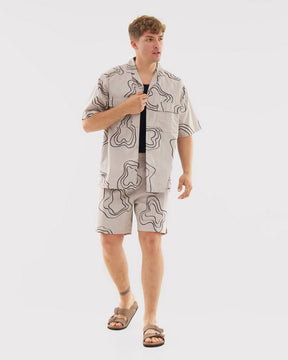 Mann trägt gemusterte sandfarbene Shorts Spencer und passende kurzärmelige Hemdjacke, braune Sandalen