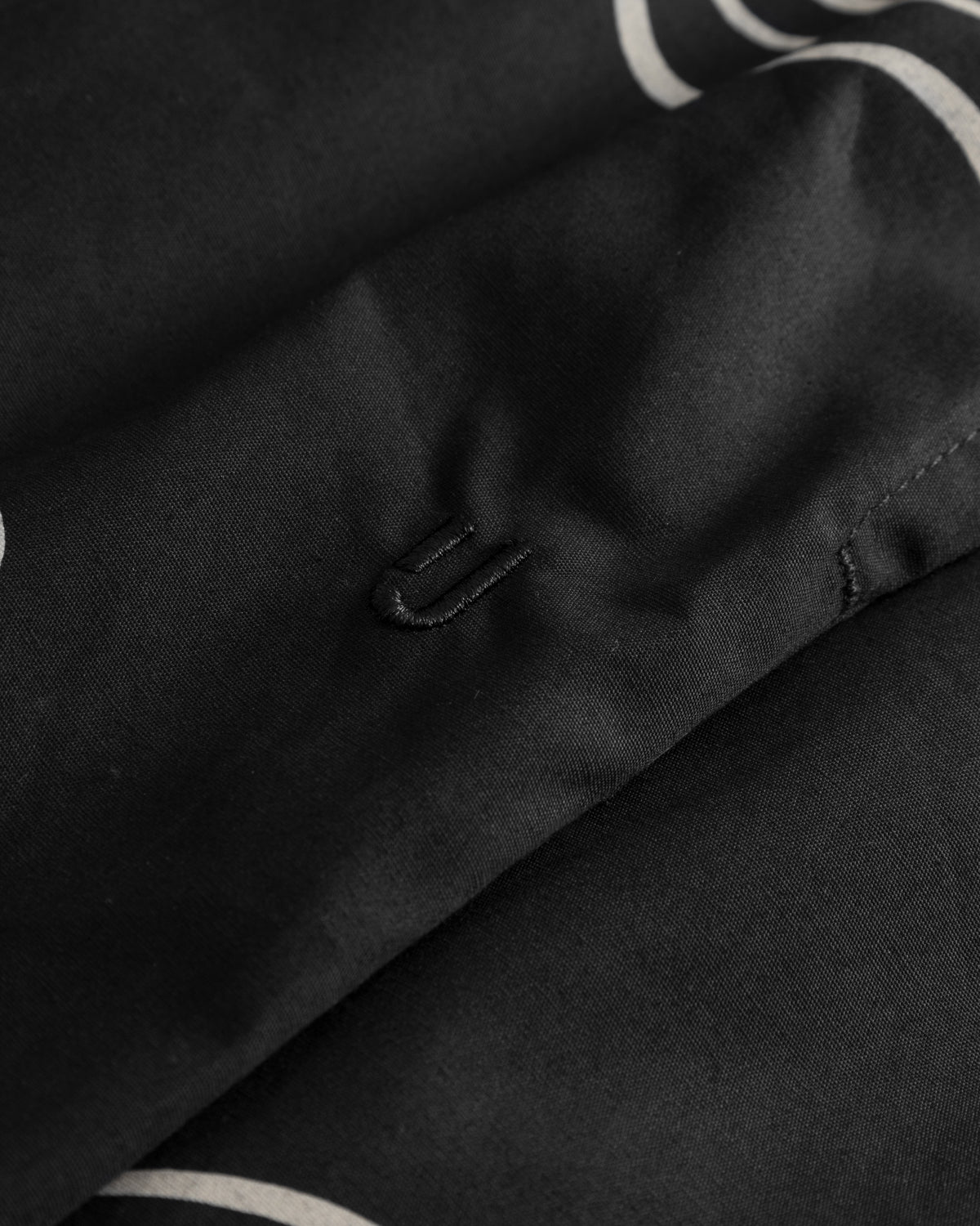 Schwarze Shorts 'Spencer' mit weißem Muster und eingesticktem 'U'-Logo