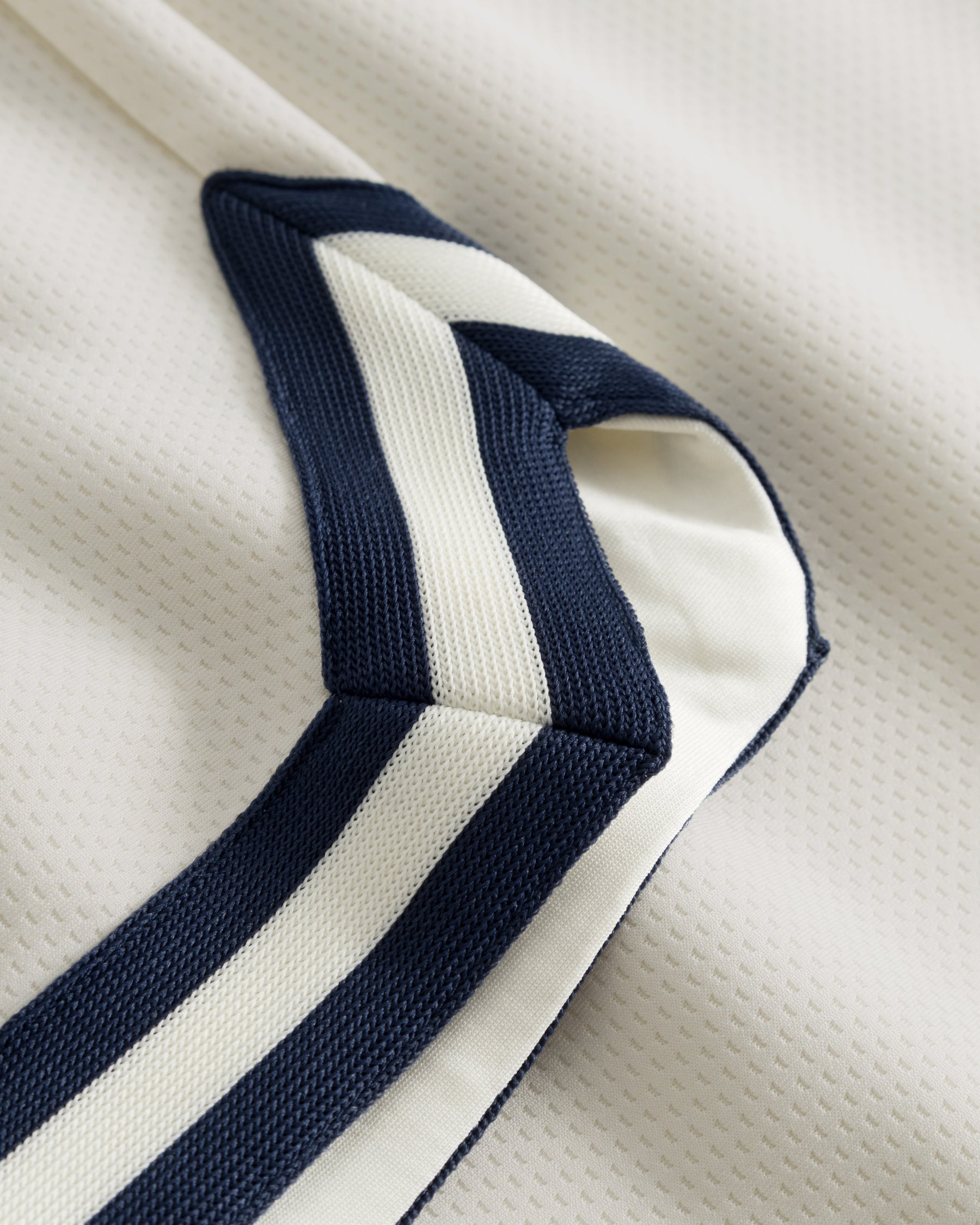 Nahaufnahme einer cremefarbenen Shorts aus dem Set 'Parker' mit dunkelblauen und weißen Streifendetails