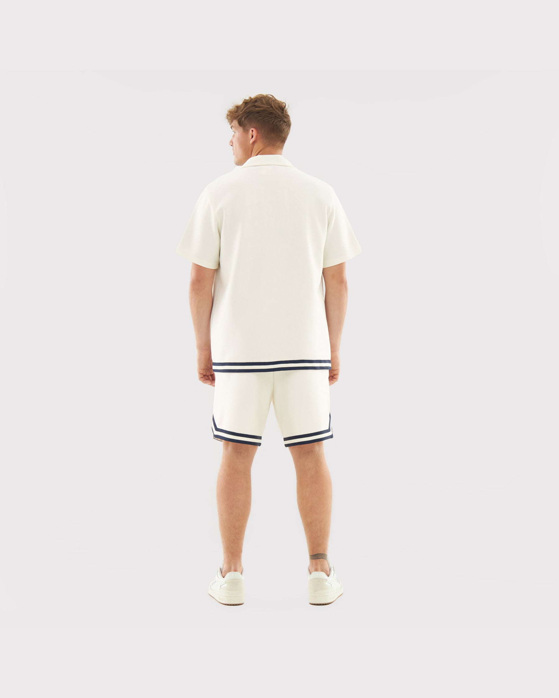 Mann von hinten in cremefarbenen Shorts 'Parker' mit dunklen Streifen am Saum