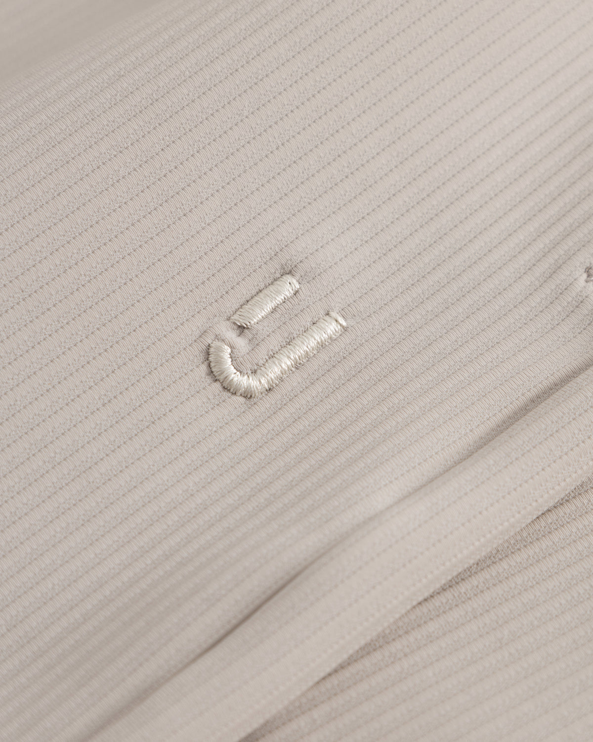 Nahe Aufnahme der sandfarbenen Stoffstruktur der Shorts 'Mason' mit feiner Rippung und gesticktem Detail