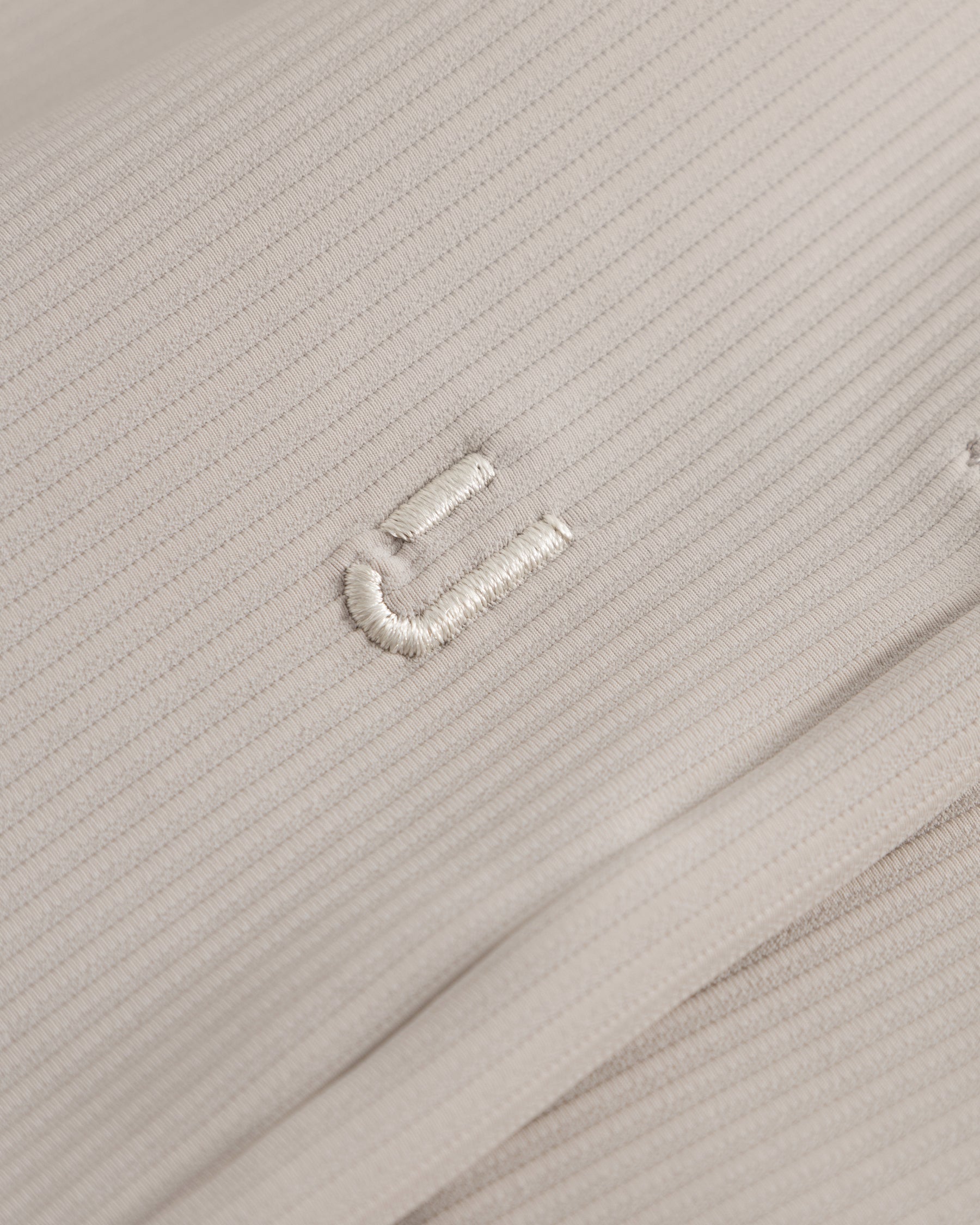 Nahe Aufnahme der sandfarbenen Stoffstruktur der Shorts 'Mason' mit feiner Rippung und gesticktem Detail
