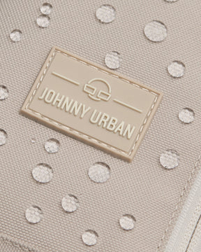 Nahaufnahme der beigen wasserabweisenden Oberfläche der Johnny Urban Sling Bag Charlie mit Wassertropfen
