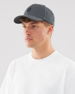 Mann trägt anthrazitgraue Snapback-Cap 'Jason' mit gebogenem Schirm und weißes T-Shirt