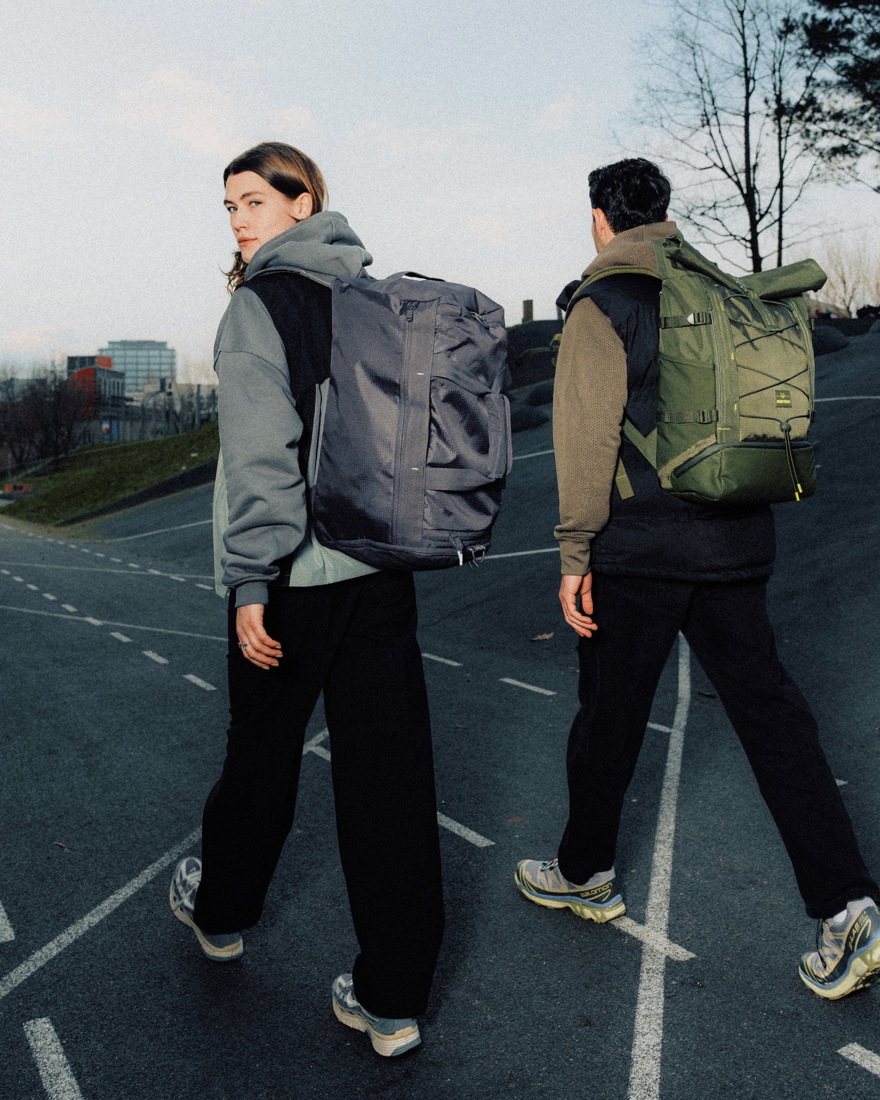 Zwei Personen gehen auf einer Straße, eine trägt eine graue Duffle Bag 'Shawn Medium' von Johnny Urban auf dem Rücken