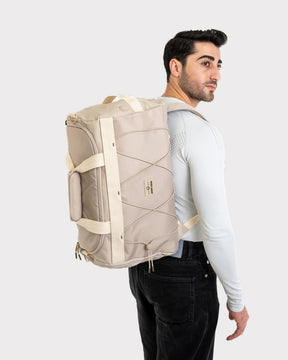 Beiger Duffle Bag 'Shawn Medium' von Johnny Urban, getragen von Mann mit weißem langärmligem Shirt und schwarzer Hose