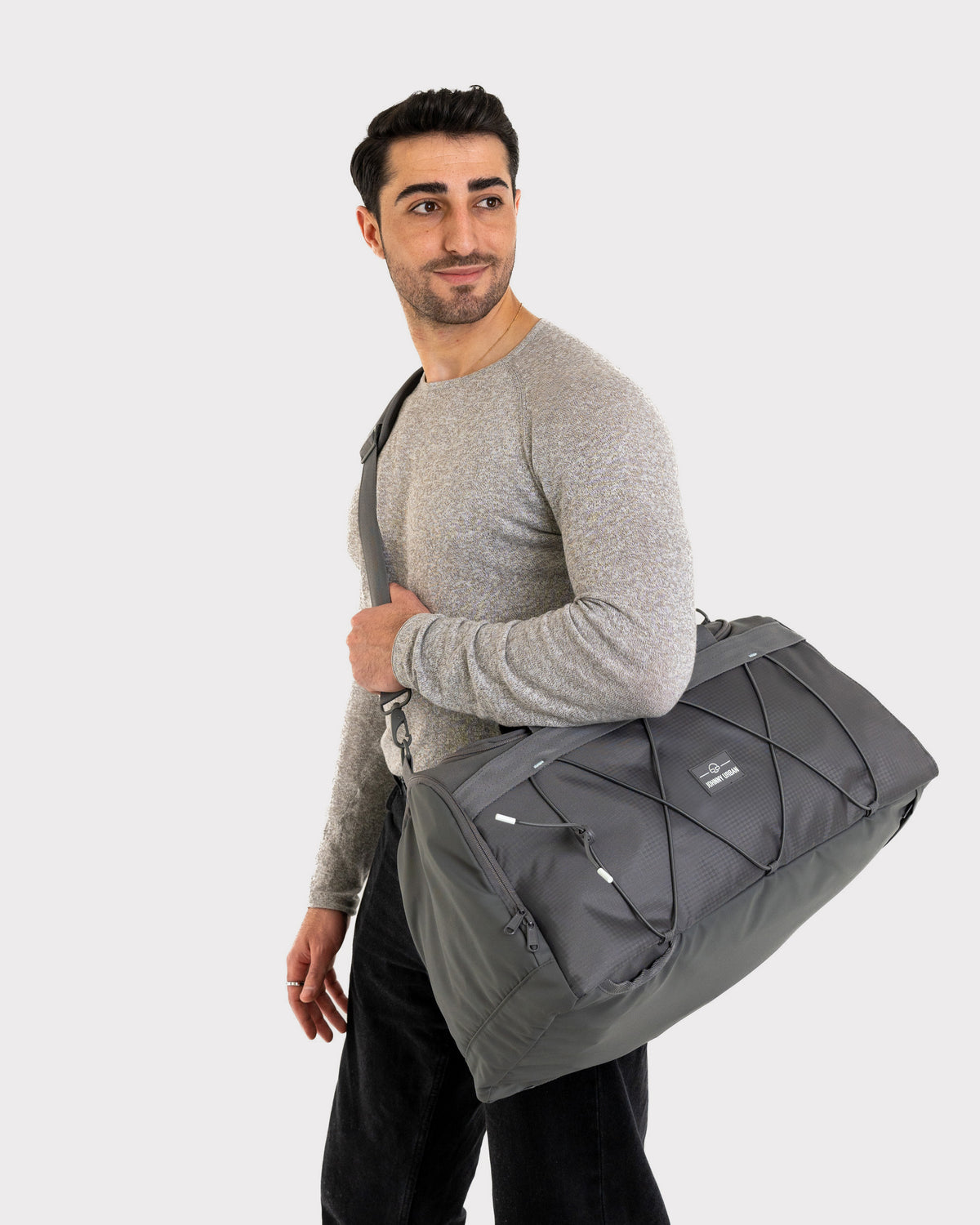 Mann trägt graue Duffle Bag 'Shawn Medium' von Johnny Urban über der Schulter