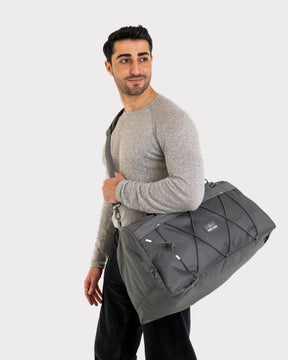 Mann trägt graue Duffle Bag 'Shawn Medium' von Johnny Urban über der Schulter