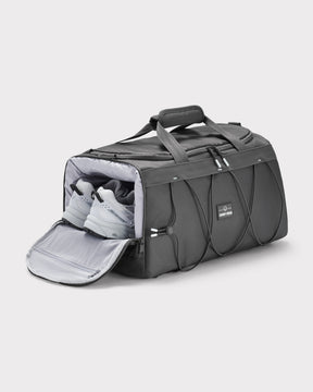 Graue Duffle Bag 'Shawn Medium' von Johnny Urban mit seitlichem Schuhfach und weißen Sportschuhen