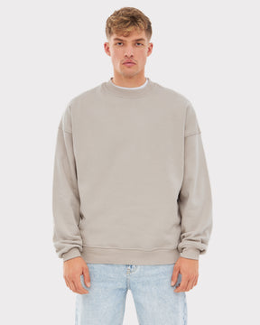 Beiger, übergroßer Herren-Crewneck-Pullover 'Carter' von Johnny Urban, getragen mit hellblauen Jeans