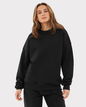 Frau trägt schwarzen Oversized Crewneck 'Carter' Pullover mit locker sitzenden Ärmeln