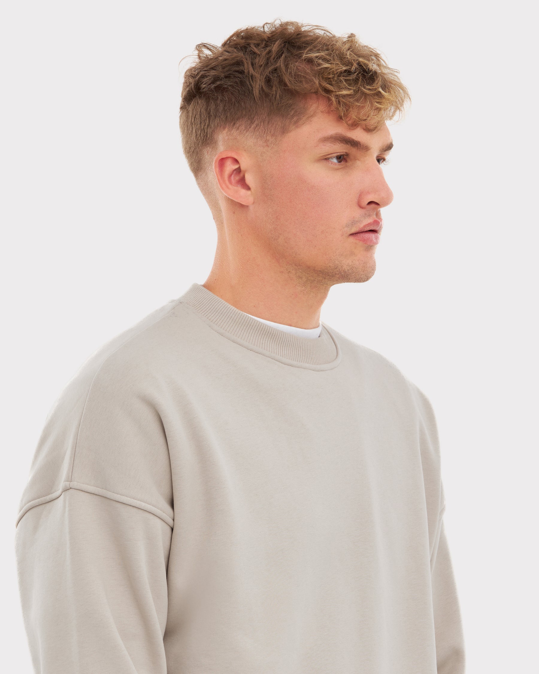 Mann im sandbeigen oversized Crewneck 'Carter' Pullover von Johnny Urban, Seitlich