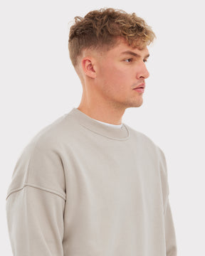 Mann im sandbeigen oversized Crewneck 'Carter' Pullover von Johnny Urban, Seitlich