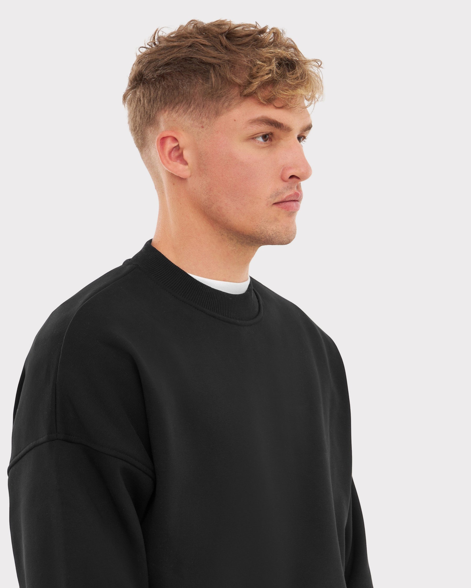 Mann trägt schwarzen oversized Crewneck Sweater 'Carter' von Johnny Urban