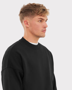 Mann trägt schwarzen oversized Crewneck Sweater 'Carter' von Johnny Urban