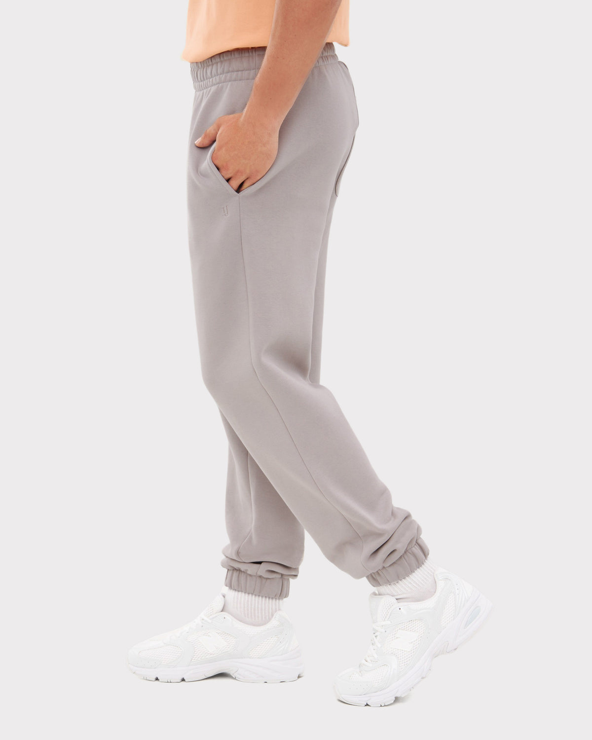 Seitliche Ansicht einer grauen Herren-Jogginghose 'Owen' mit elastischem Bund und Bündchen, getragen mit weißen Sportschuhen
