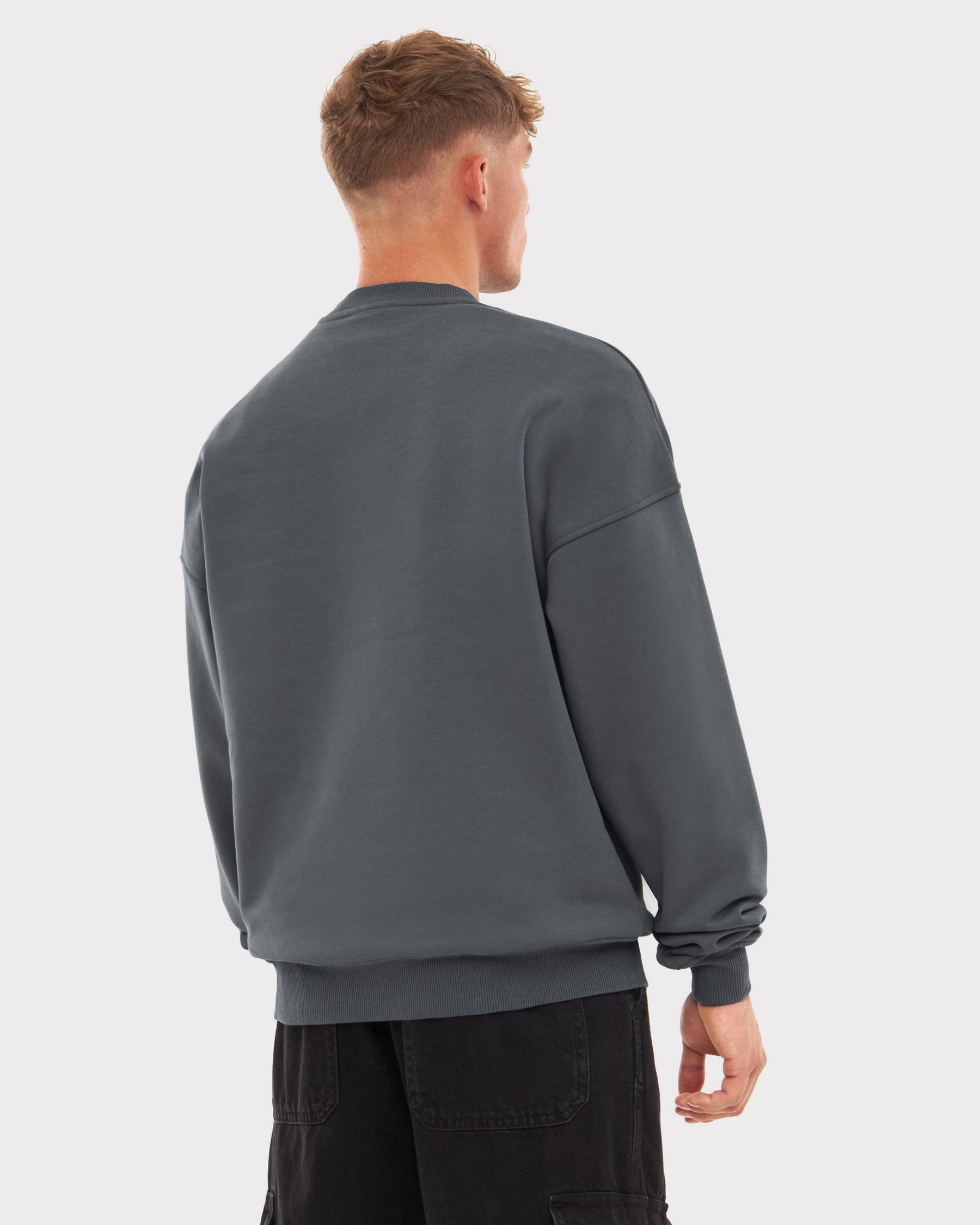 Rückansicht eines Mannes in grauem Oversized Crewneck 'Carter' Sweatshirt von Johnny Urban