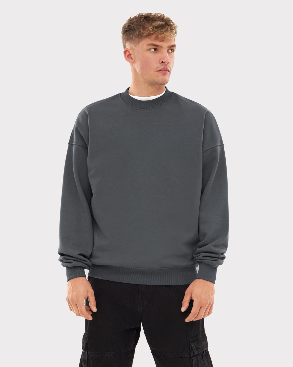 Mann trägt oversized Crewneck 'Carter' Sweatshirt in modernem Grau von Johnny Urban