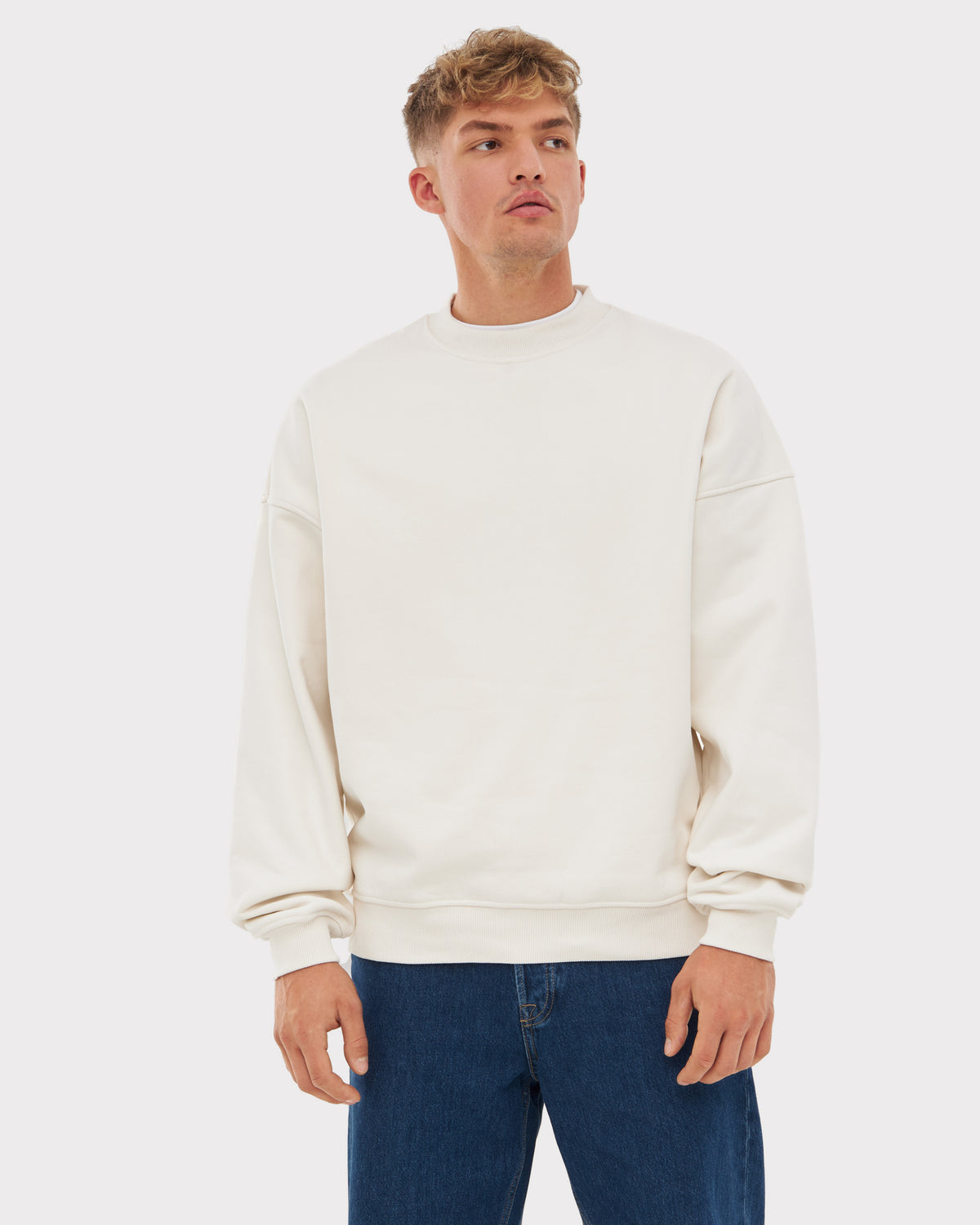 Männliches Modell trägt weißen Oversized Crewneck 'Carter' von Johnny Urban mit blauer Jeans
