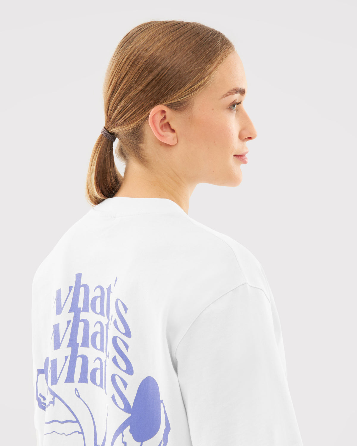 Frau mit Pferdeschwanz trägt weißes T-Shirt 'Sammy Butterfly' mit lila Text und Schmetterlingsmotiv auf dem Rücken