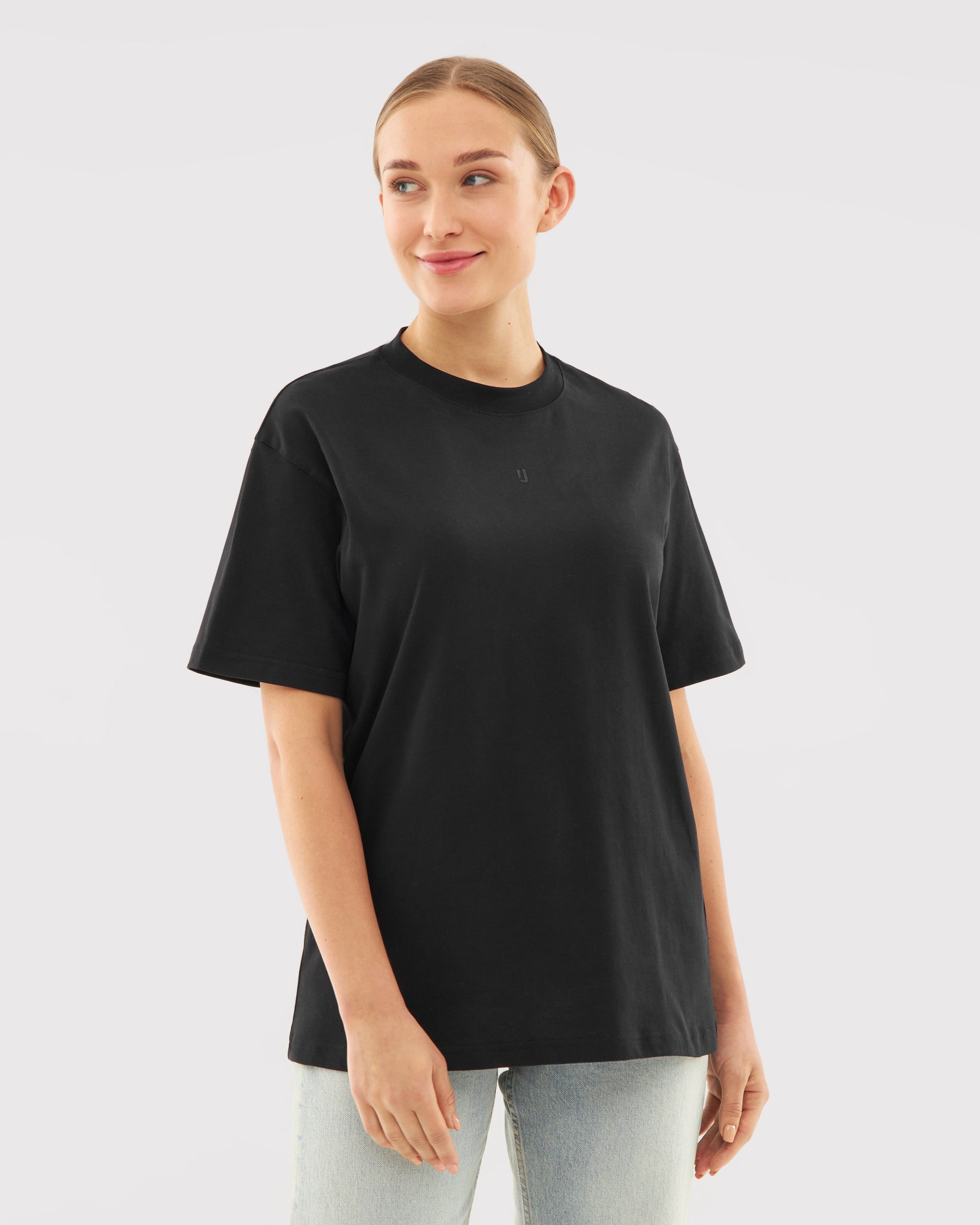 Frau trägt schwarzes T-Shirt 'Sammy Butterfly' mit dezentem Logodruck auf der Brust