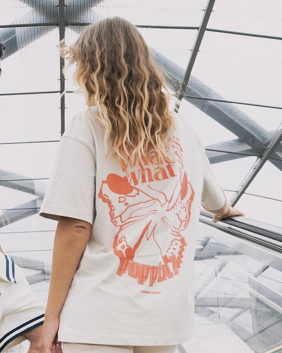 Frau trägt beiges T-Shirt mit coralrotem Backprint drauf