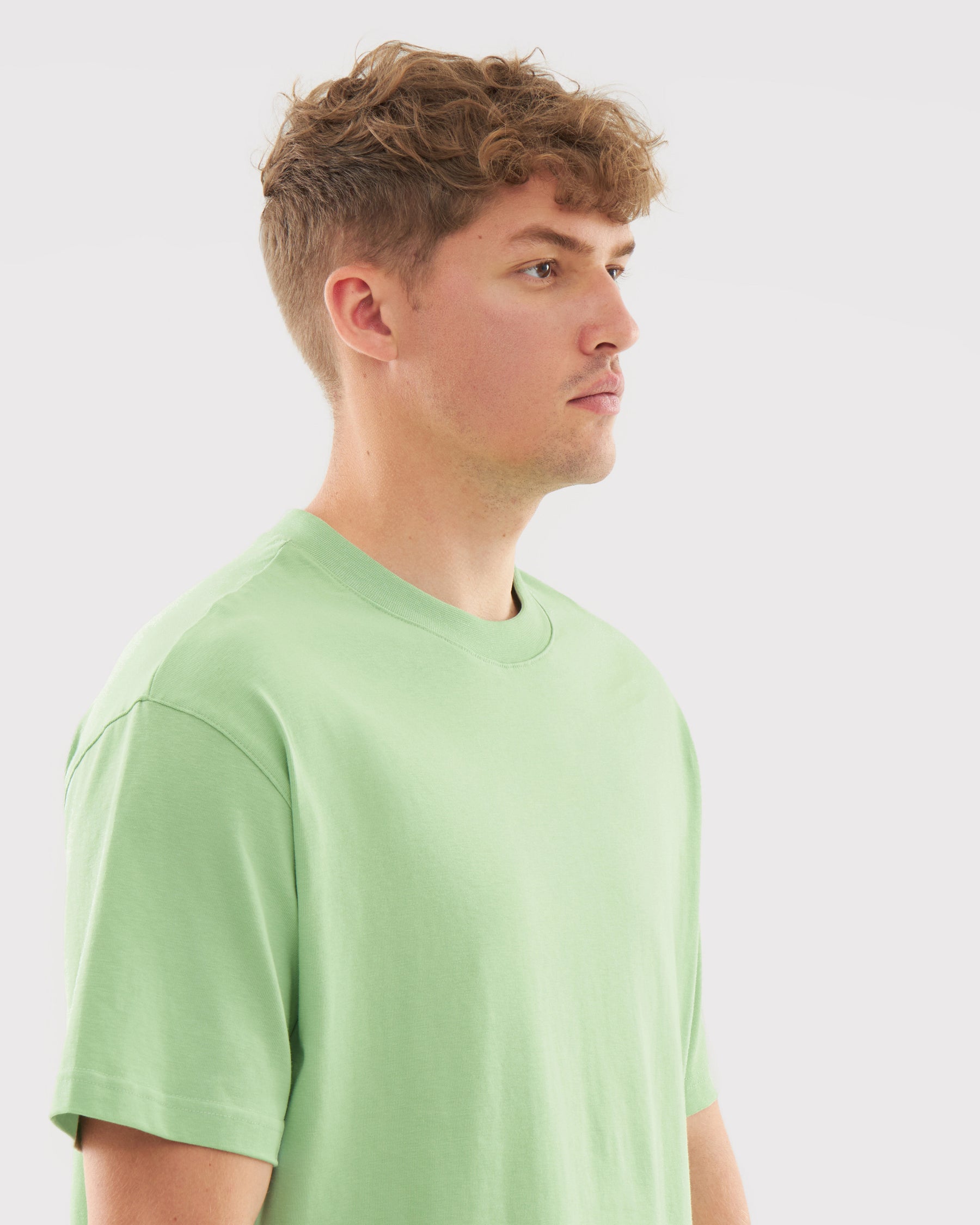 Mann im Profil trägt das sage-grüne T-Shirt 'Sammy'