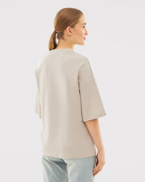 Damen trägt oversized T-Shirt 'Vic' in beige, Rückansicht, mit halblangen Ärmeln und lockerem Schnitt