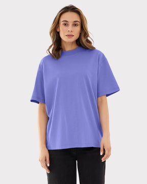 Frau trägt oversized T-Shirt 'Sammy Chrome Butterfly' in Lila mit schwarzen Hosen