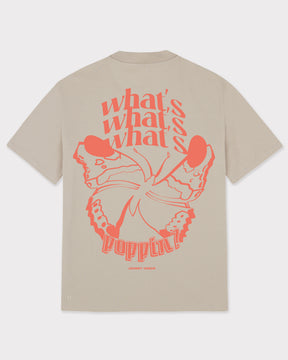 Beiges T-Shirt 'Sammy Butterfly' mit großem orangefarbenem Schmetterlingsdruck und Text 'what's poppin?' auf dem Rücken